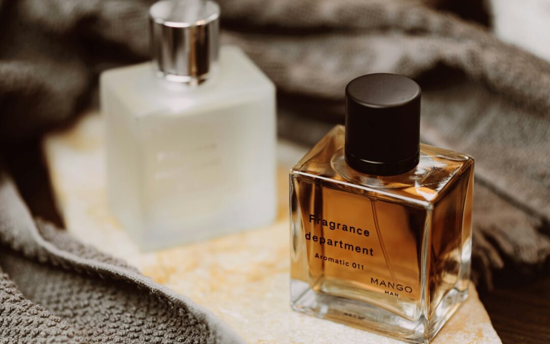 two bottles of cologne sitting on top of a blanket